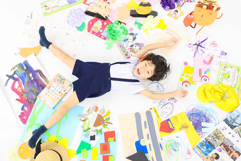 自分の作品と写真を撮る子ども